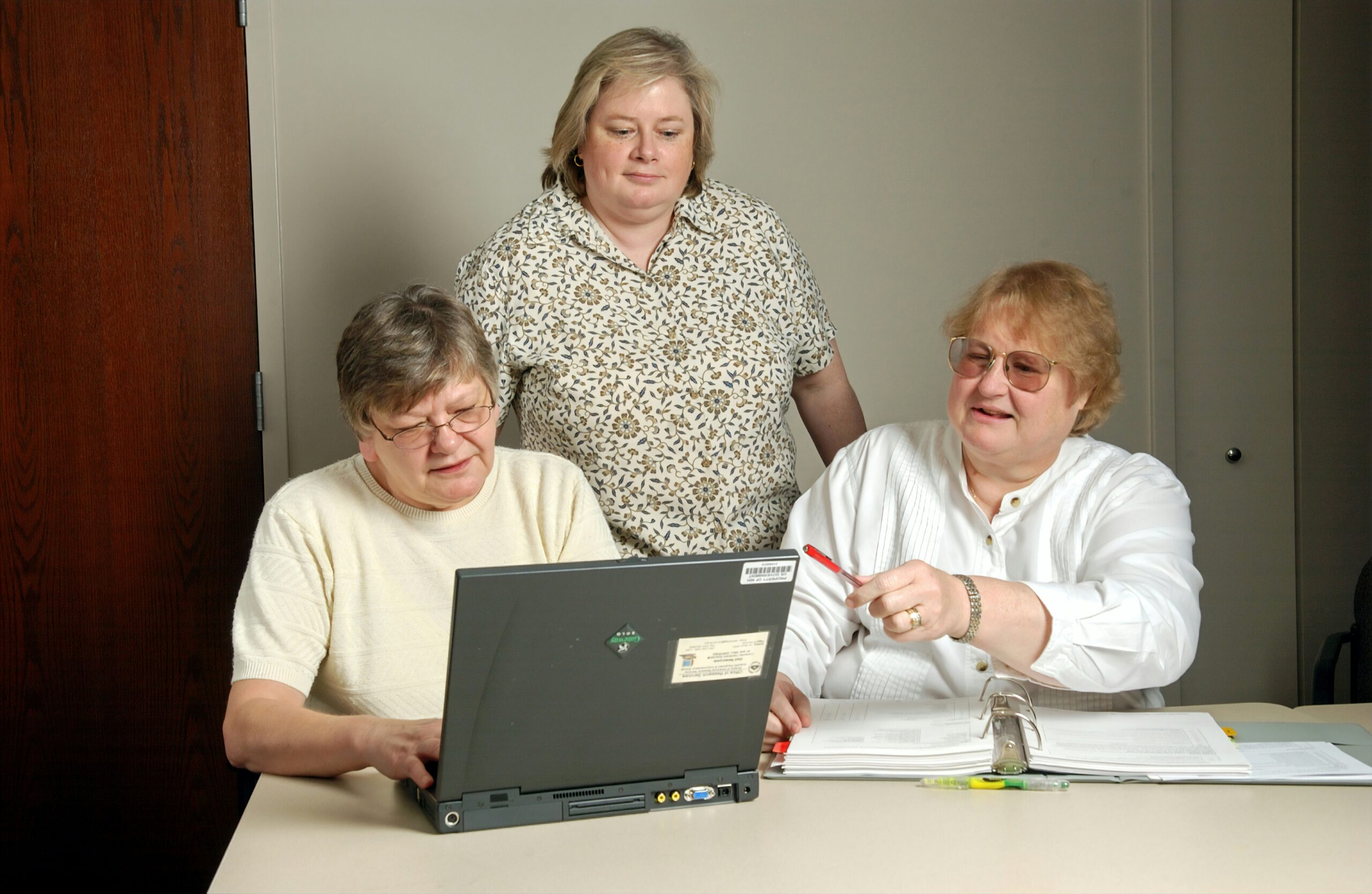 senior discussing about problem in a computer